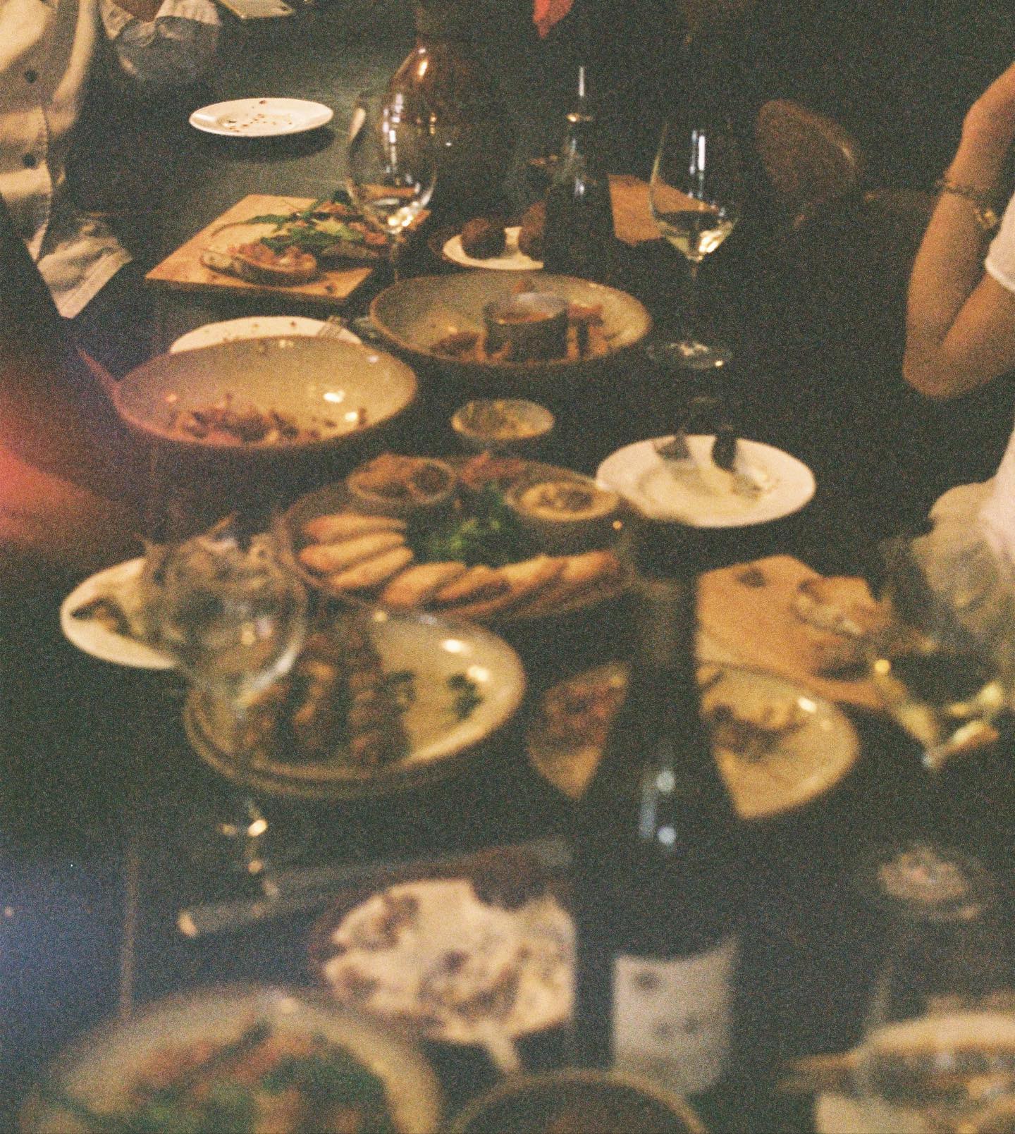 A table of sharing plates and wine at Orchard